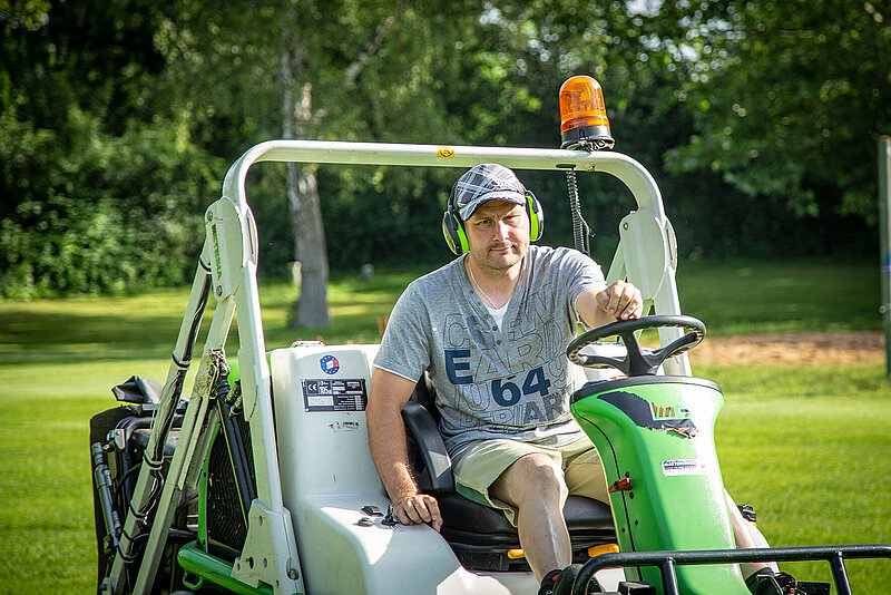 Mann fährt auf einem Rasenmäher-Traktor